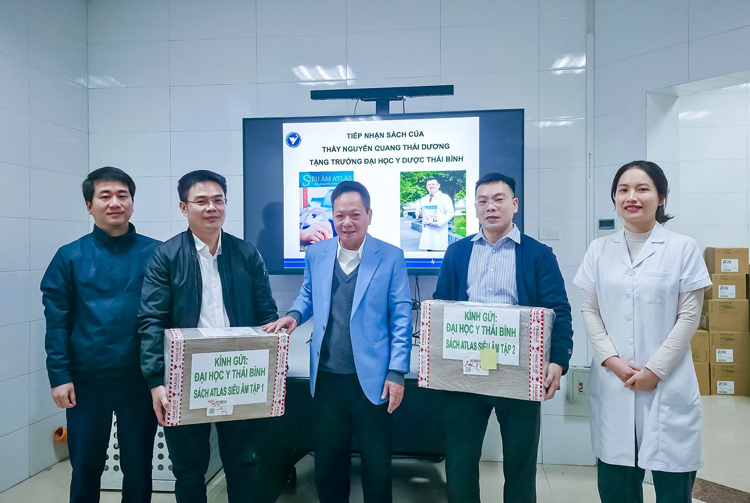 TS Nguyễn Văn Sang (áo xanh) thay mặt Bác sĩ Nguyễn Quang Thái Dương tặng sách Nhà trường